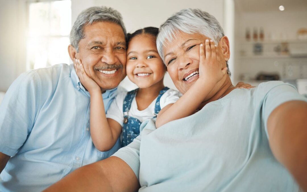 older couple smiling with granddaughter